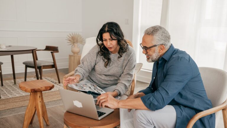 Couple looking at their laptop thinking about downsizing their home in Cambridge