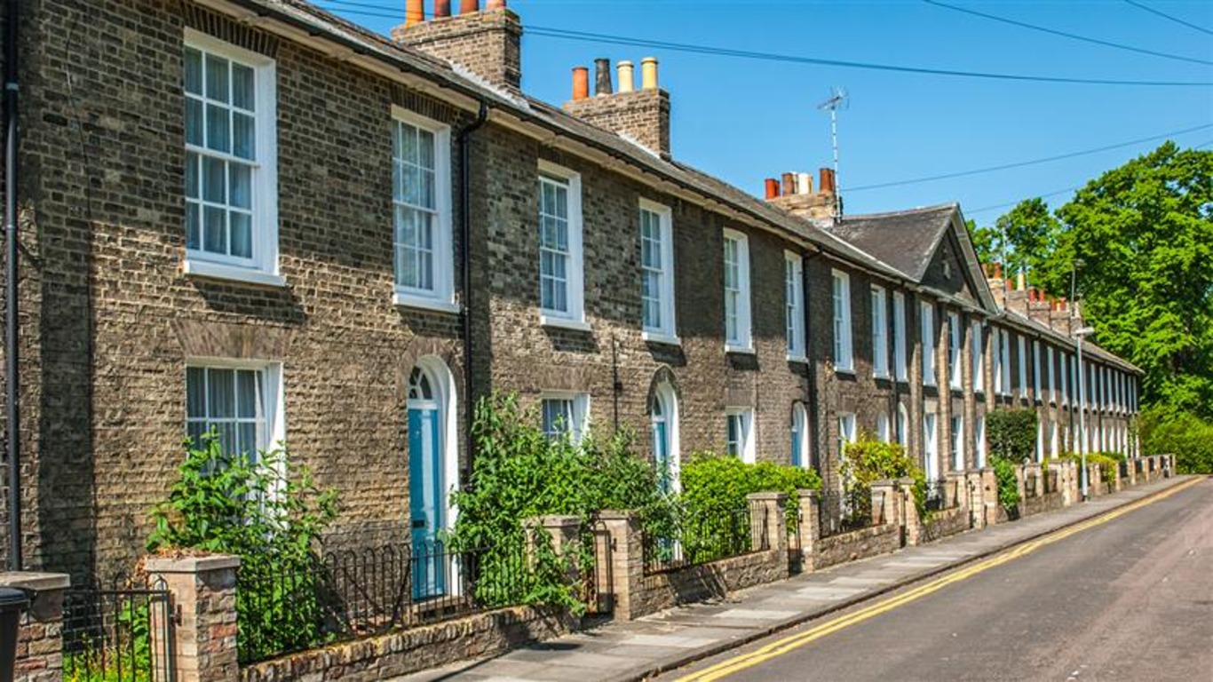 A row of terraced houses with blue doors and small gardens in Cambridge